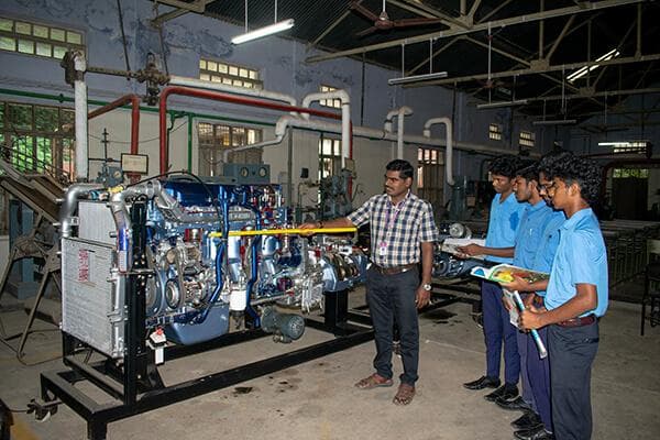 Students with faculty at the engine laboratory